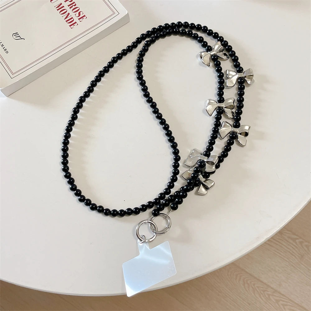 🎀 Pulsera con Lazo Plateado y Perlas – Lanyard de lujo con diseño de cadena y dije, anti pérdida, ideal para celulares